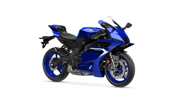 Yamaha 2025 R9 A sleek blue sports motorcycle with aerodynamic design features, positioned at an angle to showcase its profile, tires, and dual exhaust system.
