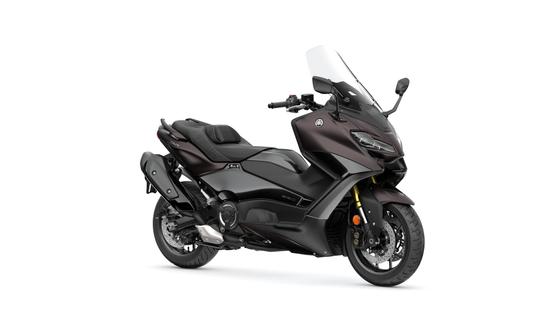 A sleek black Yamaha TMAX scooter with a windshield, showcasing its aerodynamic design, positioned at a slight angle on a white background.