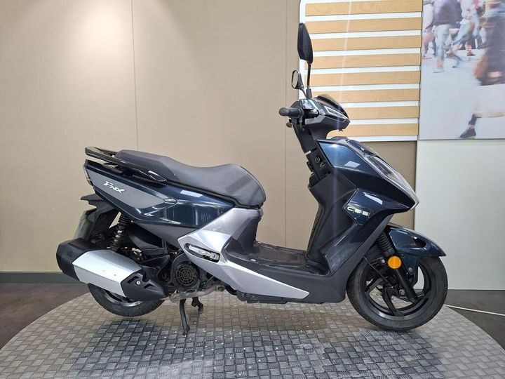 SYM FNX 125 2020 A sleek blue and silver scooter parked on a textured surface, featuring a comfortable seat, a compact design, and rearview mirrors.