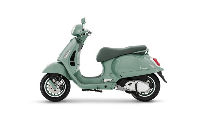 A mint green Vespa scooter shown from the side, featuring a classic design, comfortable seat, and alloy wheels.