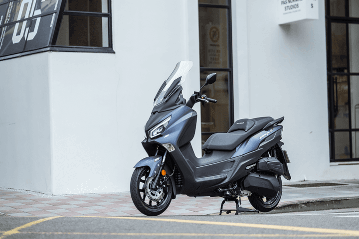 Left facing Joymax Z on the street with a white wall backdrop