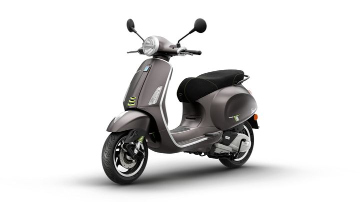 A sleek, modern scooter in a muted gray color with green accents, featuring a comfortable seat and classic design elements, positioned against a white background.