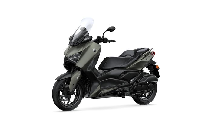 A sleek, modern scooter with a matte green and black finish, featuring a tall windshield, comfortable seating, and sporty design elements, displayed on a white background.