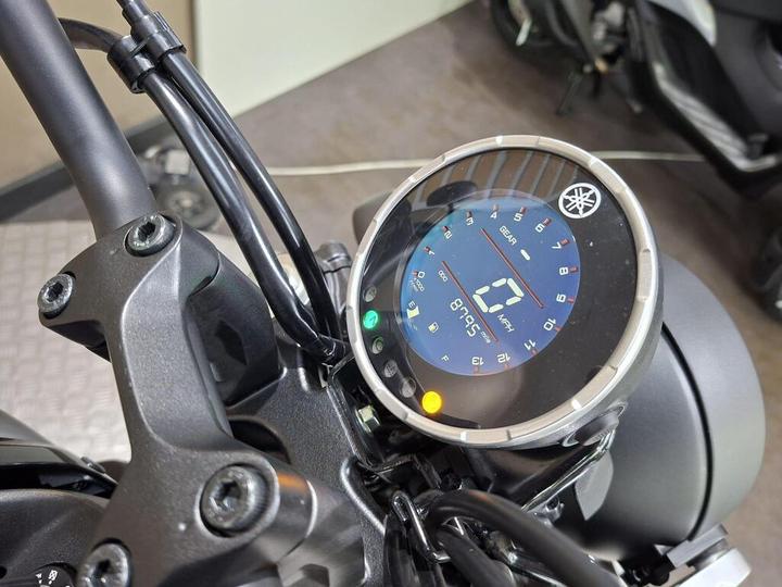 Close-up view of a motorcycle's digital display, showing speed, gear, and other indicators, mounted on the handlebars.