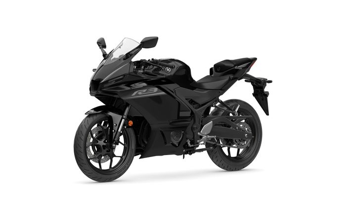 A sleek black sport motorcycle, model Yamaha R3, positioned at a slight angle showcasing its aerodynamic design, front fairing, and distinctive features.