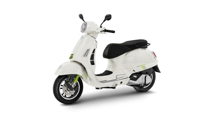 A sleek white scooter with black accents and a stylish design, featuring a round headlight, a black seat, and bright green highlights on the front.