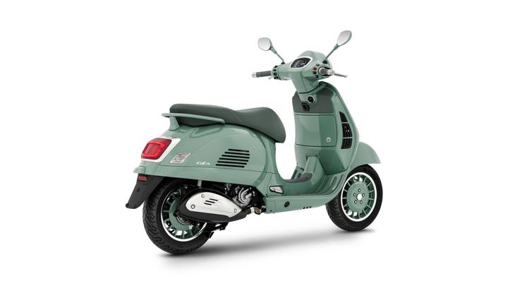 A light green scooter positioned at an angle, showcasing its sleek design, detailing of the rear body, and wheels.