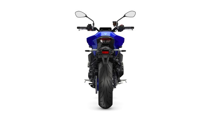 A blue motorcycle viewed from the rear, displaying its sleek design, large rear tire, and handlebars with mirrors.