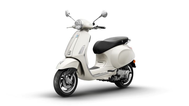 A classic white scooter with a black seat, featuring a chrome front fender and mirrors, positioned against a plain white background.