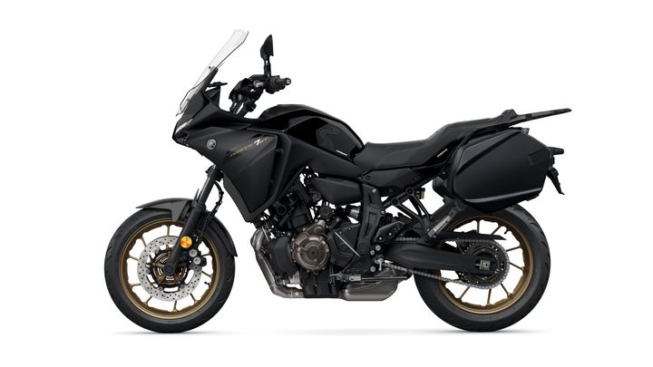 A sleek black touring motorcycle with gold-accented wheels and saddlebags, featuring a high windshield and sporty design elements.