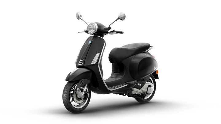 A sleek black scooter with a vintage design, featuring a round headlight, chrome accents, and a comfortable seat, positioned at a slight angle against a white background.