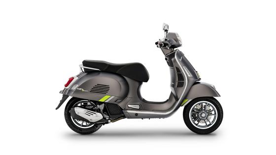 A sleek gray scooter with lime green accents, viewed from the side, showcasing its modern design and chrome details.
