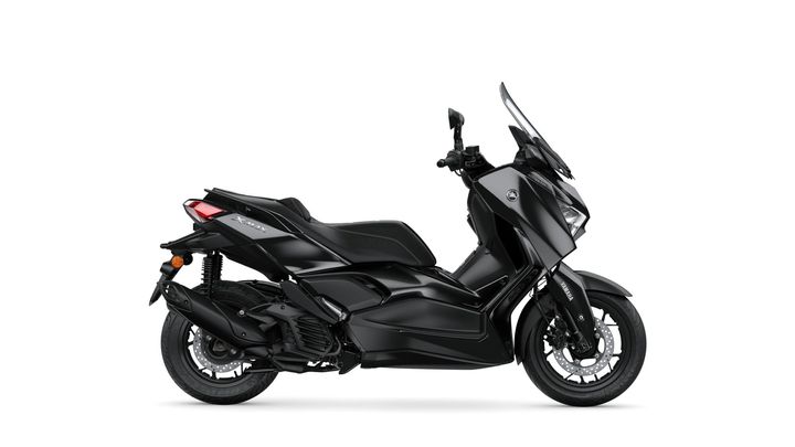 A sleek, black scooter with a modern design, featuring a windscreen, comfortable seating, and sporty detailing, presented in a side view.