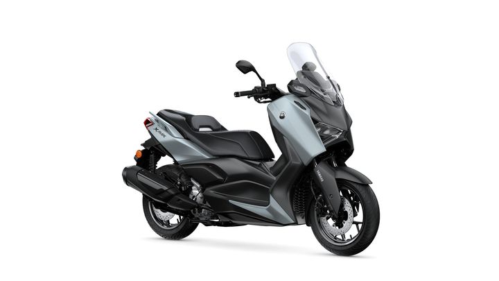 Yamaha 2025 XMAX 300 Tech MAX+ A sleek, modern scooter in a light blue and black color scheme, featuring a tall windshield, comfortable seat, and a sporty design, positioned at an angle to display its profile and wheel.