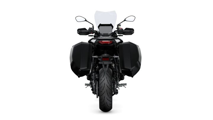 Rear view of a motorcycle with a black body, side bags, and a visible rear tire, set against a white background.