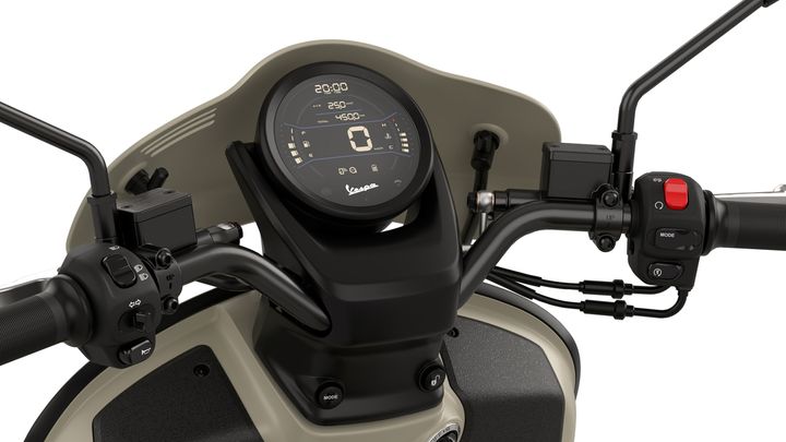 Close-up view of a motorcycle dashboard featuring a digital display with speedometer and odometer readings, alongside handlebar controls including buttons and switches.
