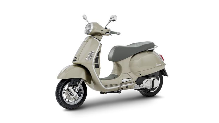 A light beige Vespa scooter with a gray seat, shown from the side on a white background.