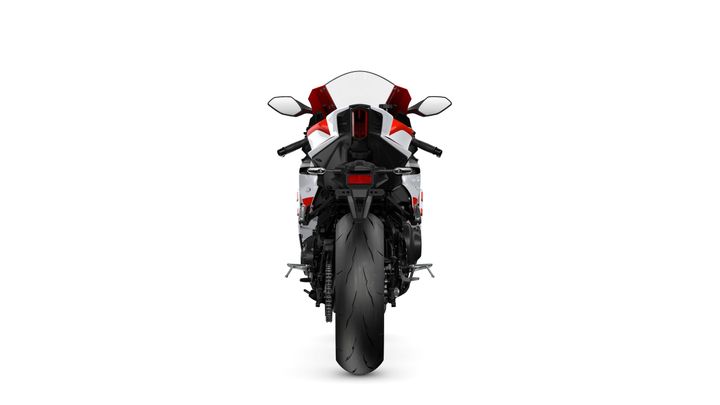 A rear view of a sleek motorcycle with a red and white color scheme, showcasing its dual exhaust pipes, large rear tire, and modern design features against a white background.