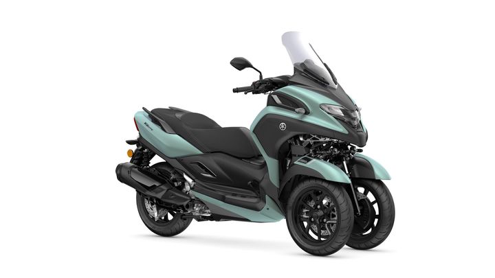 A turquoise and black three-wheeled scooter with a sporty design, featuring a windshield, sleek bodywork, and dual front wheels.