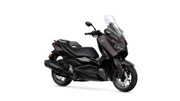 A sleek, modern black scooter with a tall windscreen, sporty design, and a low-profile seat, showcasing its stylish elements and robust tires.