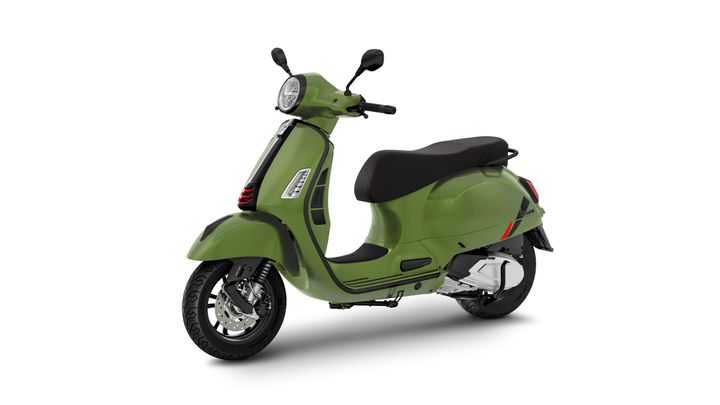 A green scooter with a sleek design, featuring a black seat with red stitching, front headlight, and stylish wheels, positioned on a white background.