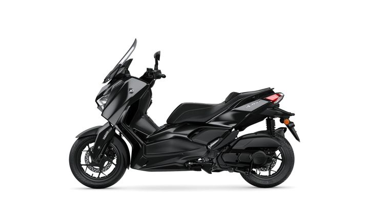 A sleek black scooter with a streamlined design, featuring a tall windshield, sporty front fender, and dual-tone seat, displayed against a white background.
