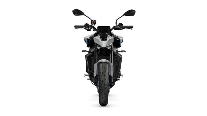 A modern motorcycle viewed from the front, featuring a sleek design, prominent headlight, and a large front tire.