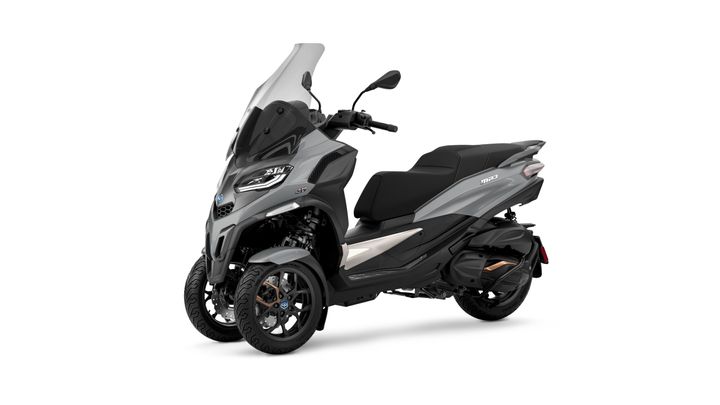A sleek gray three-wheeled scooter with a large windscreen, sporty design elements, and modern details, parked against a white background.