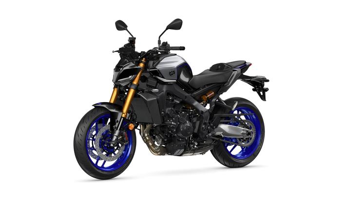 A sleek, modern motorcycle in black, silver, and blue colors, featuring a sharp design, gold front forks, and alloy wheels with blue accents, positioned against a white background.
