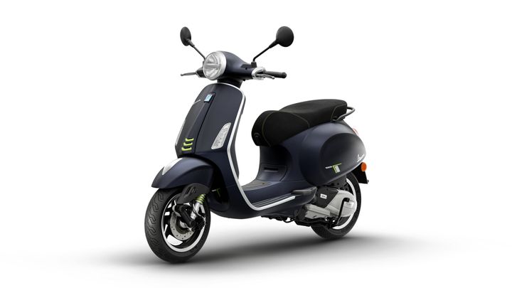 A modern black scooter with a sleek design, featuring a round headlight, green accents, and a cushioned seat, positioned against a white background.