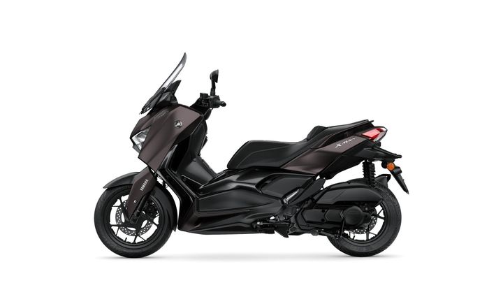 A sleek, modern Yamaha XMAX scooter in a dark metallic finish, shown from the side with a clear view of its contours, seat, and wheels against a white background.