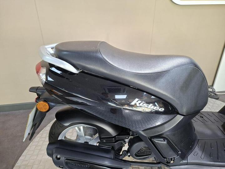 A close-up view of the seat and rear section of a black Peugeot Kisbee scooter, showcasing its sleek design and reflective surfaces.