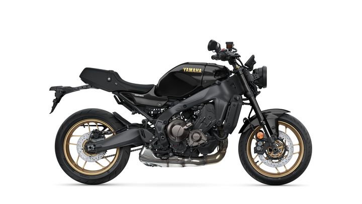 A sleek, modern Yamaha motorcycle in matte black with gold accents, showcasing a sporty design, exposed engine components, and a distinctive silhouette.