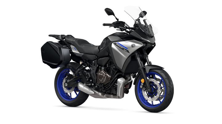 Yamaha 2023 Tracer 7 GT A sleek gray Yamaha Tracer 9 GT motorcycle is shown, featuring blue wheels, a tall windshield, and side luggage. The bike has a sporty design with a prominent engine and modern aesthetics, positioned on a white background.