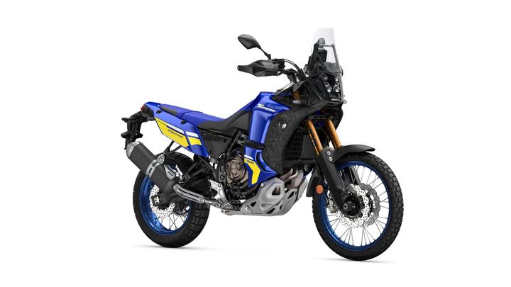 Yamaha 2024 Ténéré 700 World Raid A blue and yellow adventure motorcycle with knobby tires, a tall windshield, and a prominent front headlight, positioned on a white background.