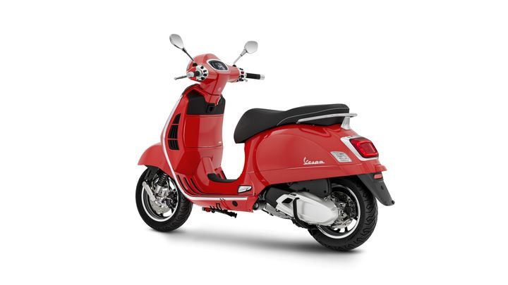 A red Vespa scooter viewed from the rear, showcasing its shiny body, sleek design, and chrome accents.