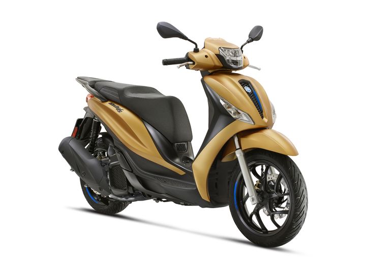 A gold and black scooter positioned at a slight angle, showcasing its body, wheels, and handlebars against a white background.