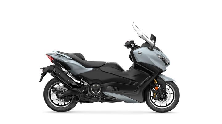 A sleek grey scooter with a sporty design, featuring a prominent windshield, modern headlights, and a black seat. The bike is positioned on a white background, showcasing its curvy body and stylish wheels.