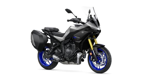Yamaha 2026 Tracer 7 GT A sleek black and silver motorcycle with blue wheels, equipped with a windshield and side luggage, positioned on a white background.