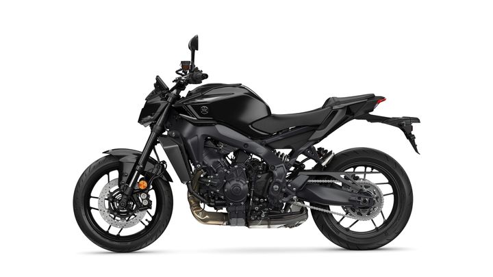 A sleek black motorcycle with a modern design, featuring a minimalistic body, wide tires, and a streamlined profile, parked against a plain white background.
