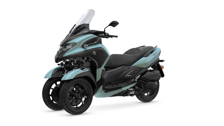 A teal and black three-wheeled scooter from the side, featuring a sleek design, large windshield, and sporty tires.