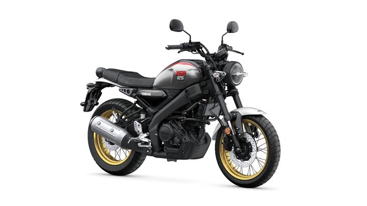 Yamaha 2025 XSR 125 Legacy motorcycle in gray with a black seat, featuring a round headlight, silver exhaust, and gold rims, positioned on a white background.