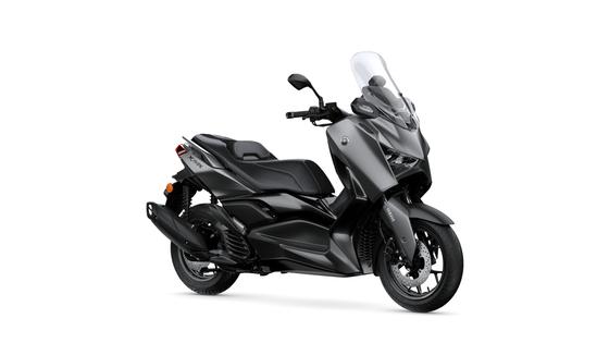 Yamaha 2026 XMAX 125 Tech MAX+ A sleek, modern gray scooter with a prominent front windshield, comfortable seat, and sporty design, showcasing its side profile against a white background.