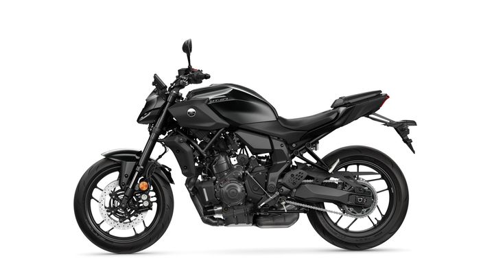 A sleek black motorcycle viewed from the side, showcasing its sporty design and modern features, including a sharp headlight and prominent engine.