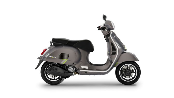 A sleek grey scooter with green accents, featuring a comfortable seat and modern design, viewed from the side.