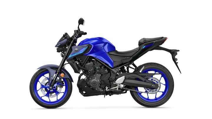 A blue and black Yamaha MT-03 motorcycle is shown in a side view, highlighting its sporty design and prominent features such as the front forks, exhaust, and styled wheels.