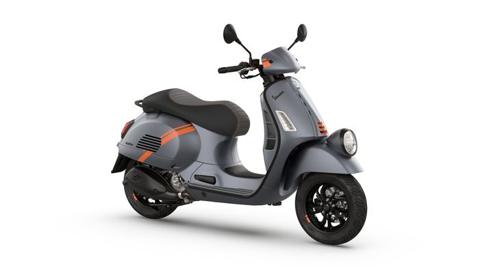 A sleek gray scooter with orange accents, featuring a comfortable seat and modern design elements, parked on a white background.