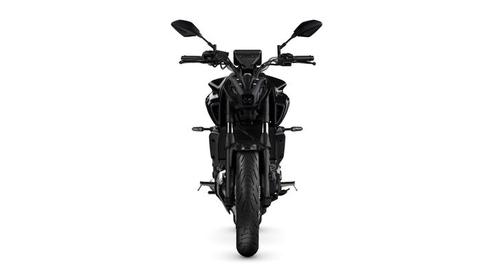 A black motorcycle viewed head-on, featuring a sleek design with prominent headlights, handlebars, and a textured tire.