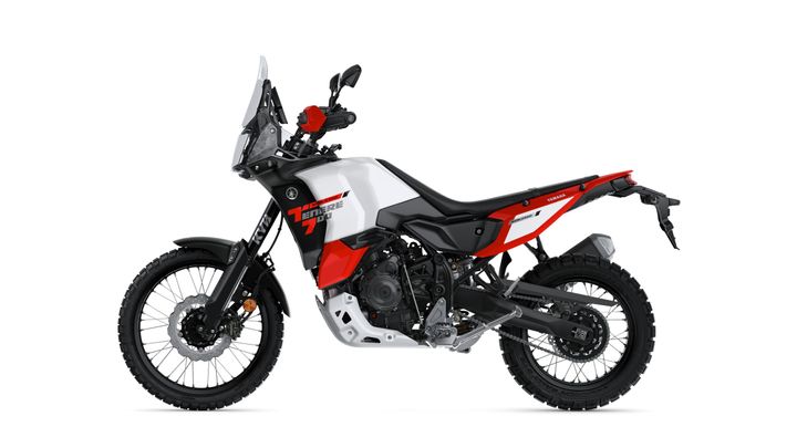 A side view of a Yamaha Tenere 700 motorcycle, showcasing its rugged design, black and red color scheme, and off-road tires.