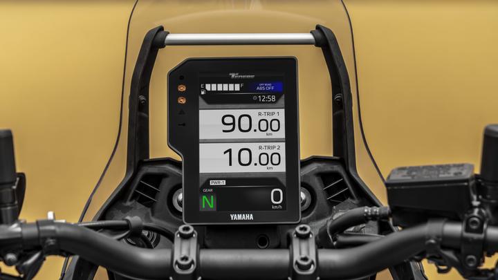 Digital display of a motorcycle dashboard showing trip distances (90.00 km and 10.00 km), time (12:58), gear (N), and a power indicator (0 km/h), with warning lights visible.